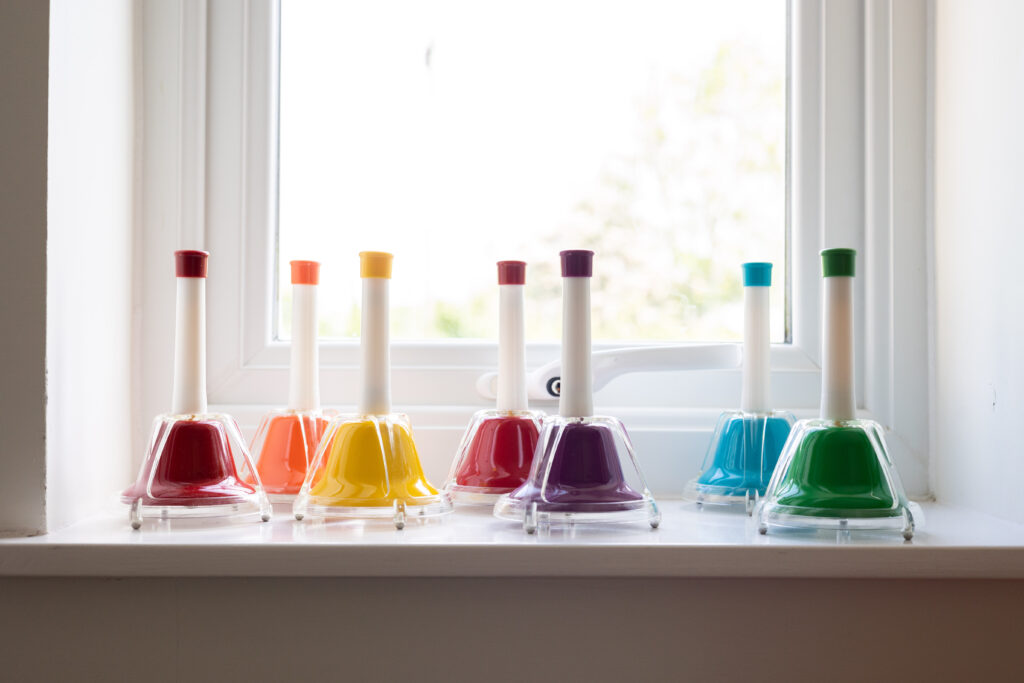 A set of small multicoloured bells sat on the windowsill in the music therapy room.
