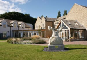A view of the rear of Russell House taken from the garden, with the stone sculpture in the foreground.
