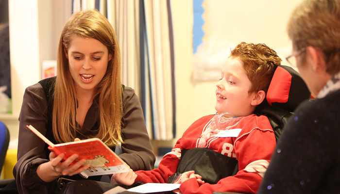 The Hospice Patron HRH Princess Beatrice reading to one of the children at the hospice.
